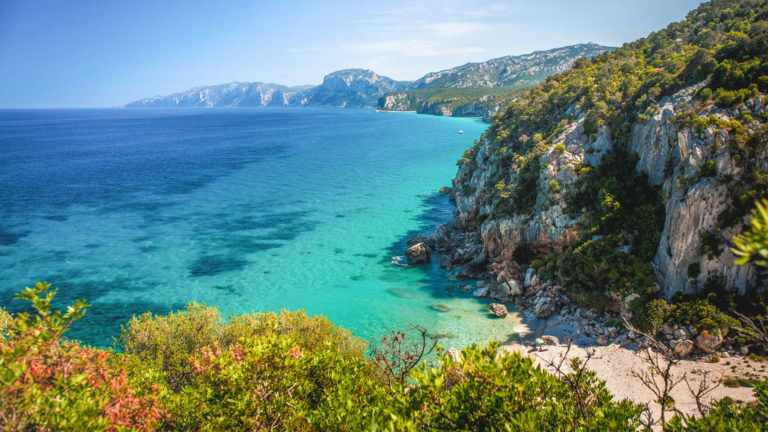 Percorso del Selvaggio Blu lungo la costa del Golfo di Orosei, Sardegna — faraglione di Pedra Longa sullo sfondo